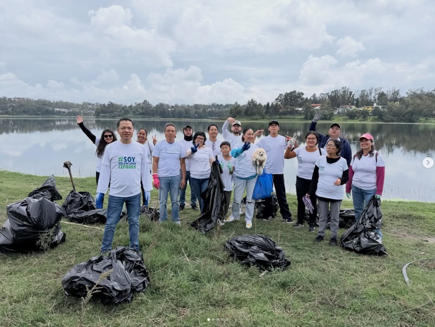 Grupo de voluntarias y voluntarios CEFODEH posando junto al Lago de Guadalupe con costales de basura recolectada